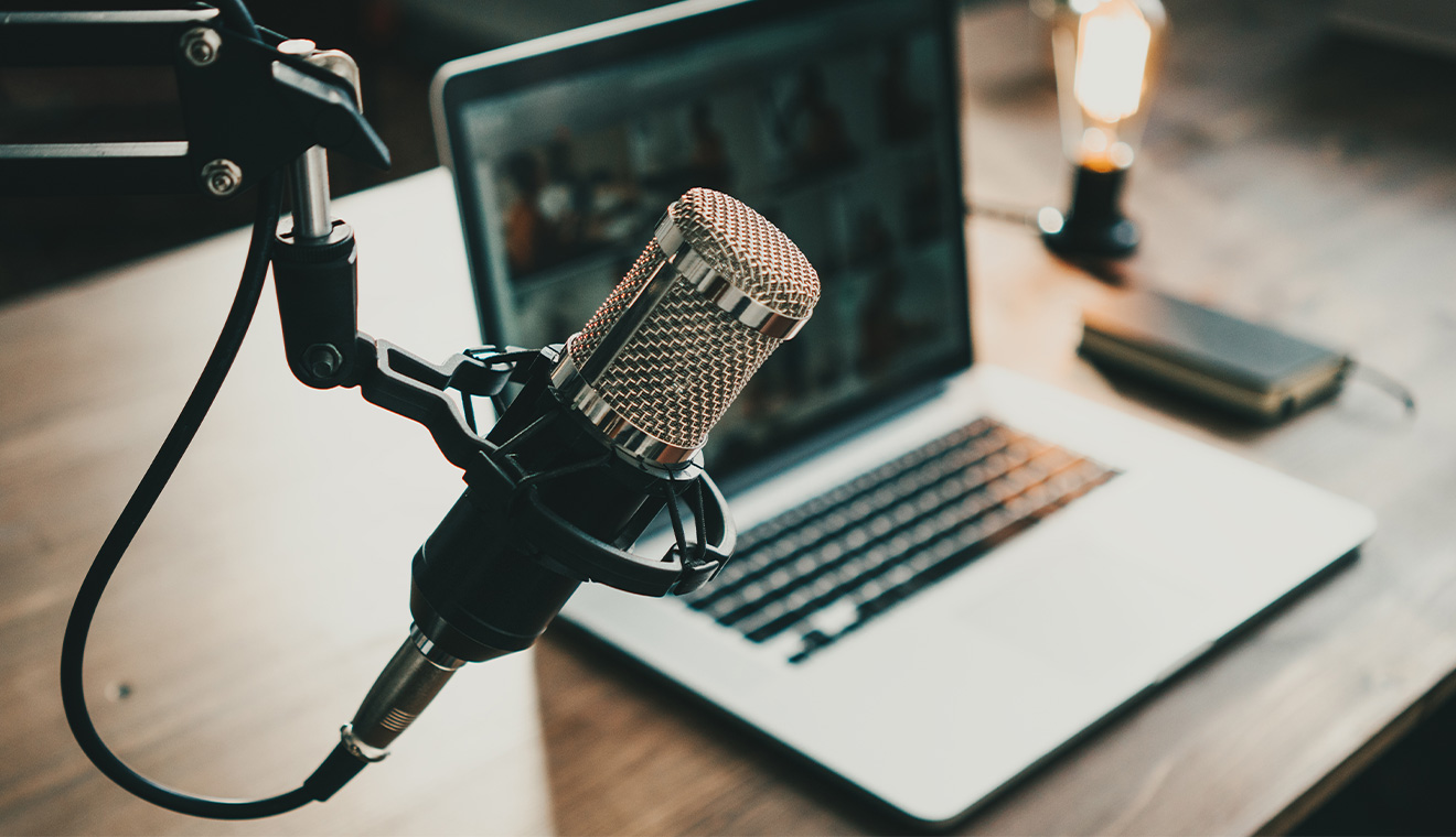 Profesjonalny mikrofon i laptop na biurku – stanowisko do nagrywania filmów lub podcastów na YouTube